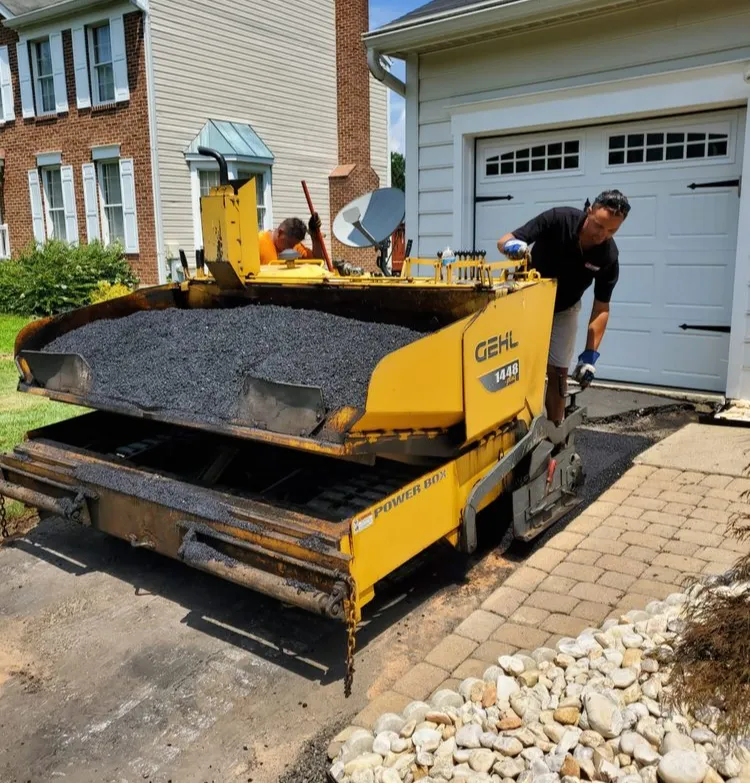A man loading asphalt onto a machine.